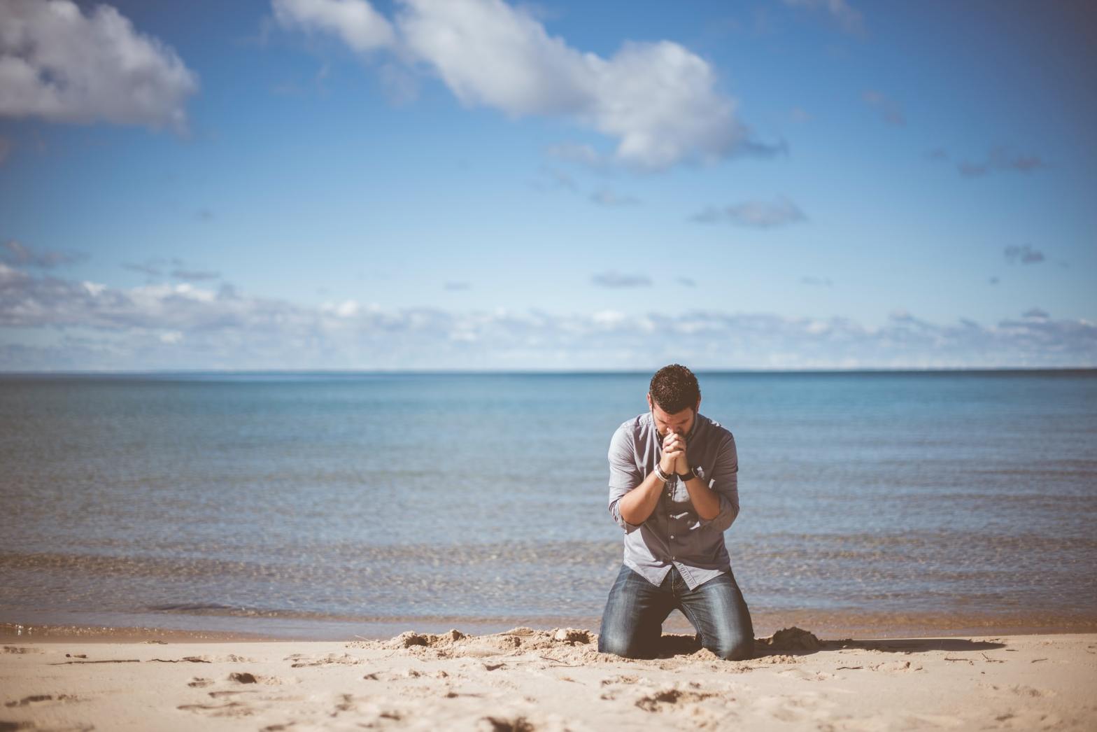 Man praying by the shore