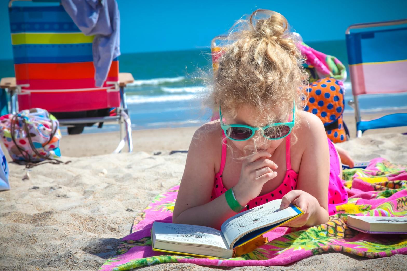 Girl reading a book by the shore